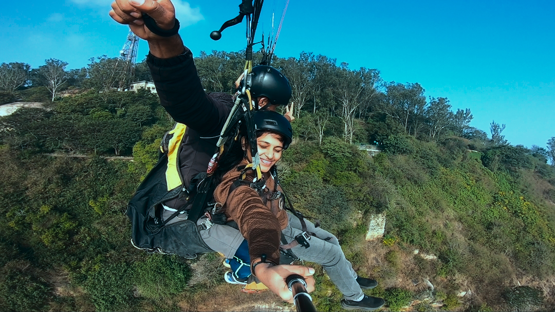 Paragliding over a green valley